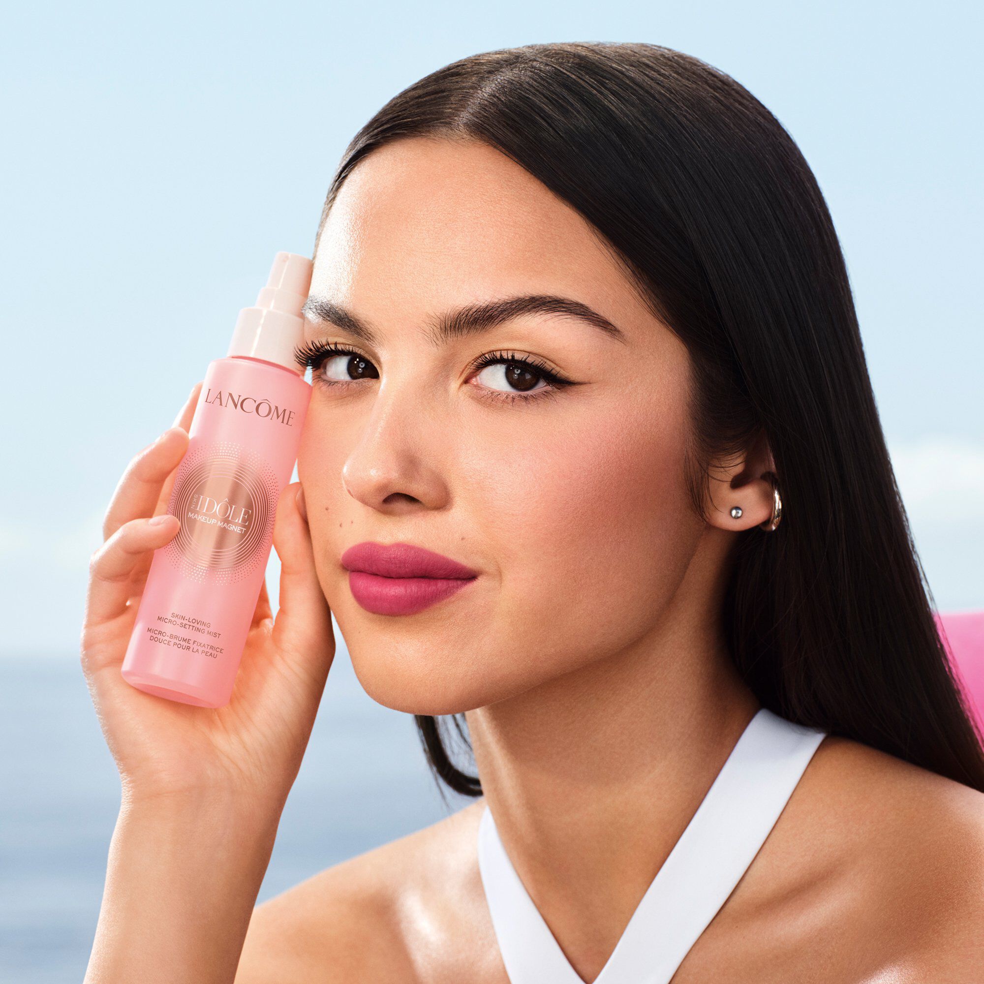  Olivia Rodrigo holding the pink Lancome setting mist bottle.