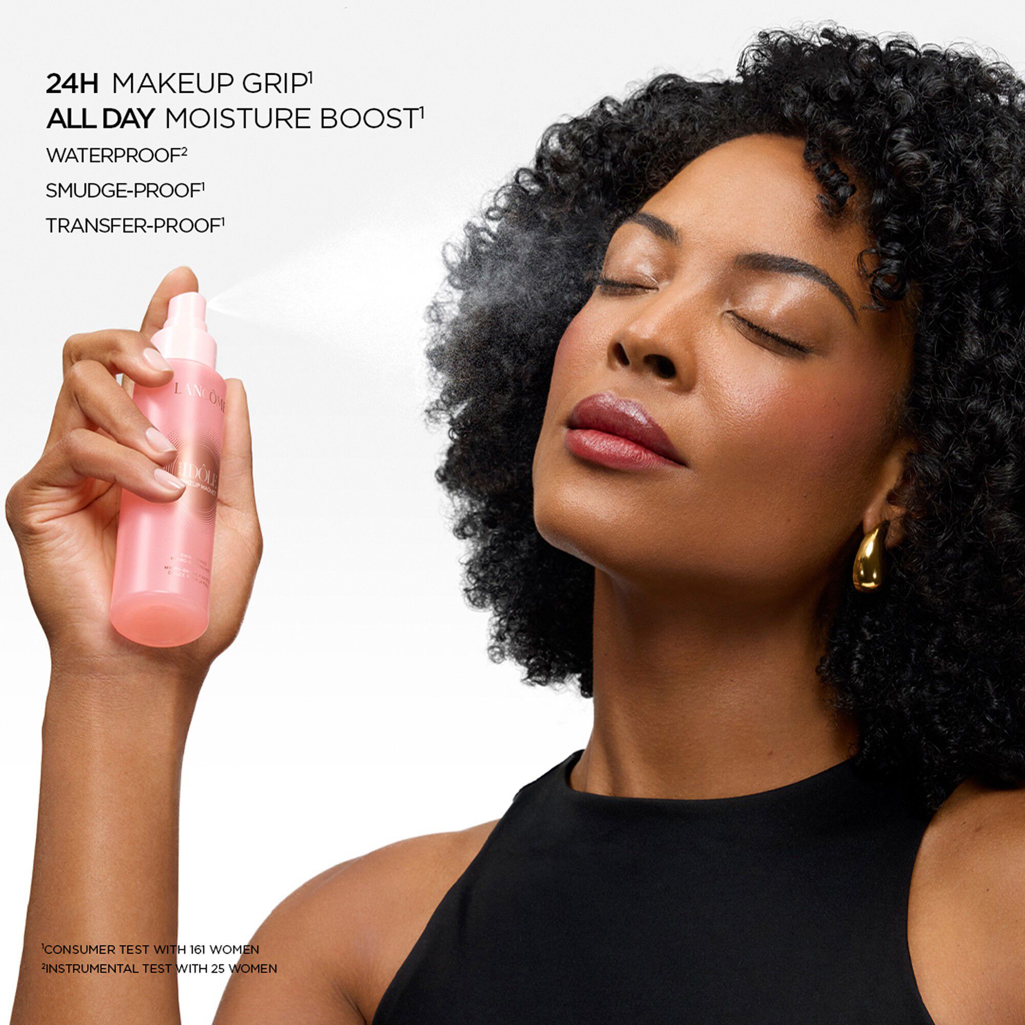 Model spraying fine setting mist on her face with eyes closed.